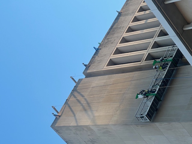 Griffin Restoration crew on a swing stage cleaning a high-rise facade