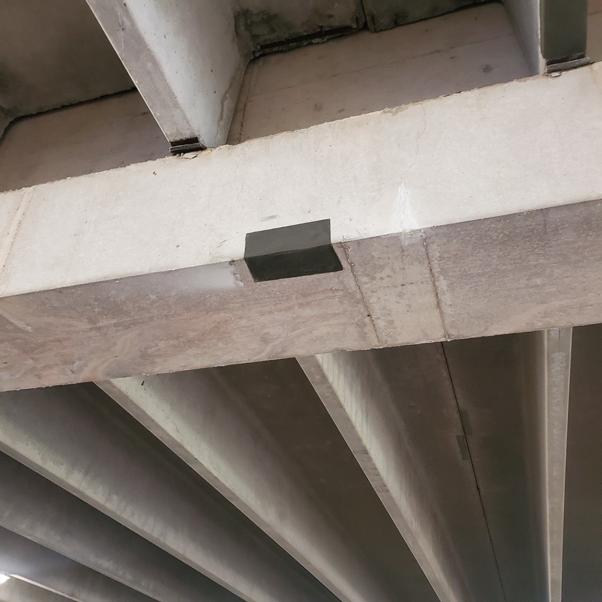 Repaired underside of parking garage concrete beam